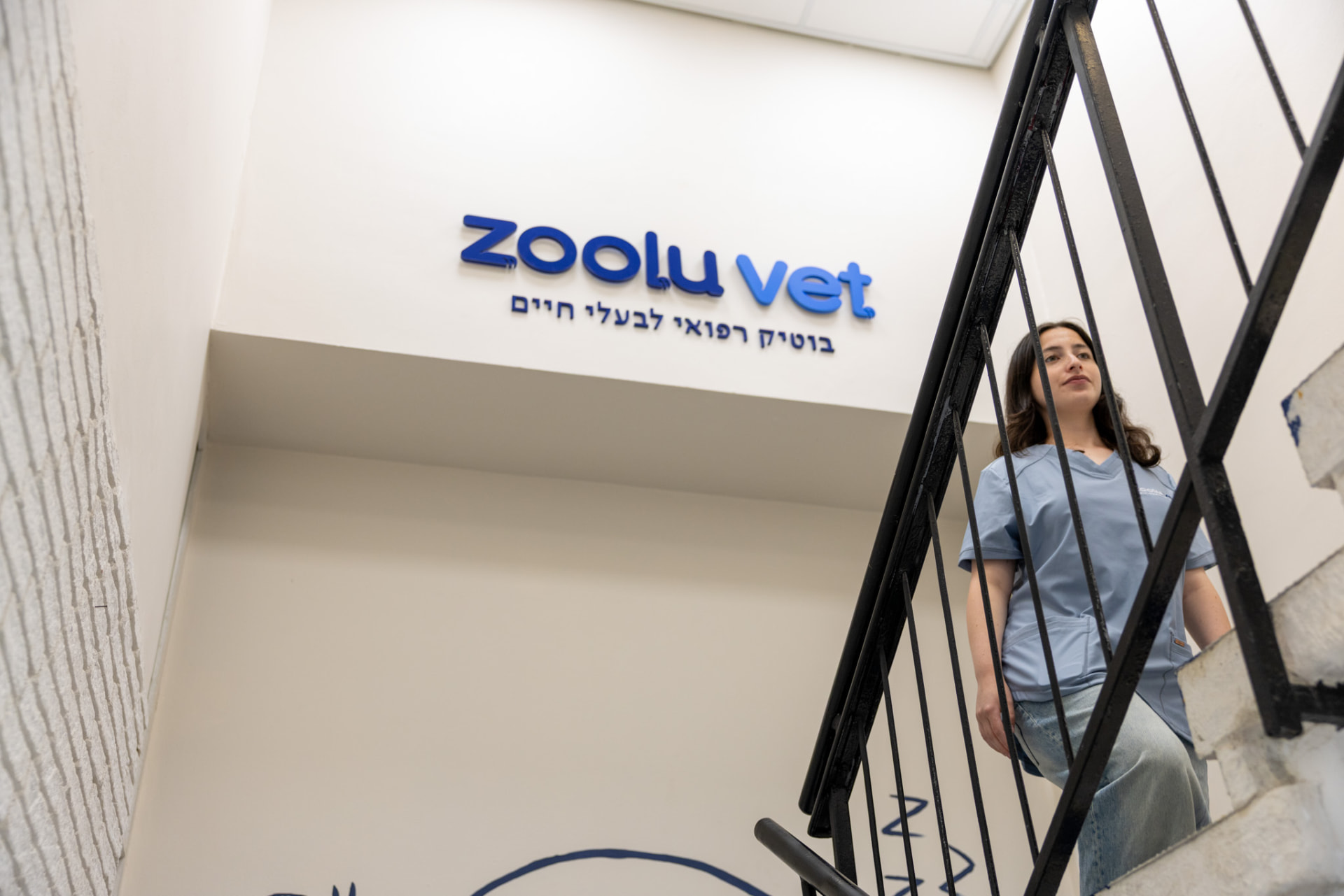 אשת צוות עולה במדרגות אל הכניסה למרפאת Zoolu Vet